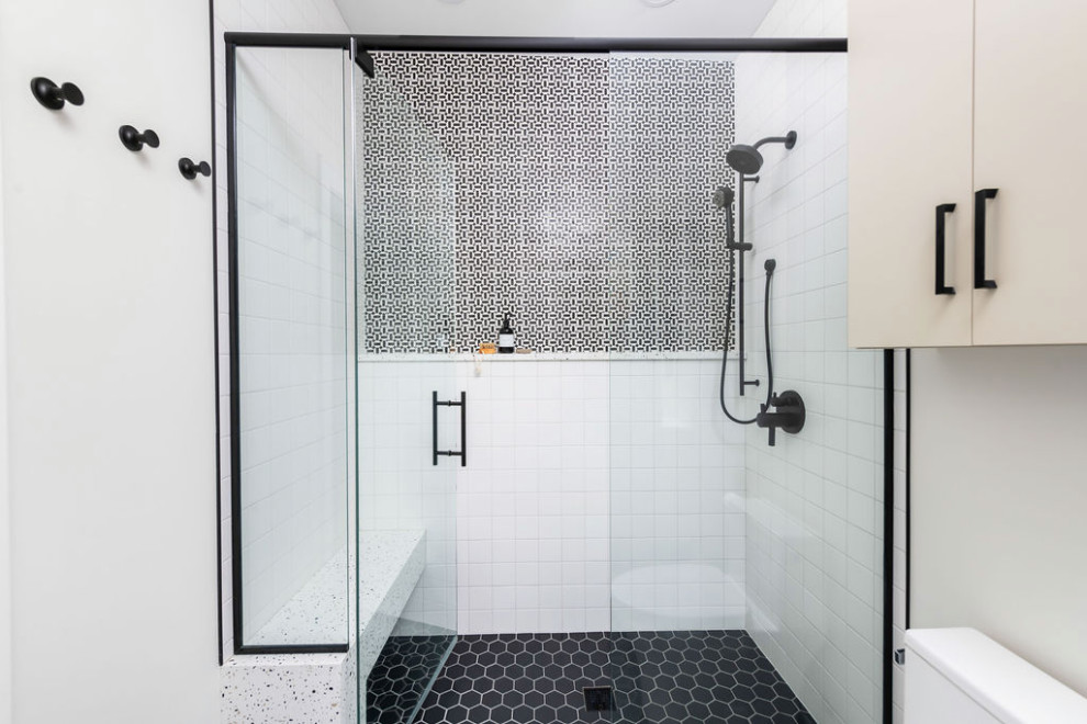 Inspiration för mellanstora moderna flerfärgat badrum med dusch, med släta luckor, beige skåp, en dusch i en alkov, vita väggar, mosaikgolv, ett nedsänkt handfat, bänkskiva i kvartsit, svart golv och dusch med gångjärnsdörr