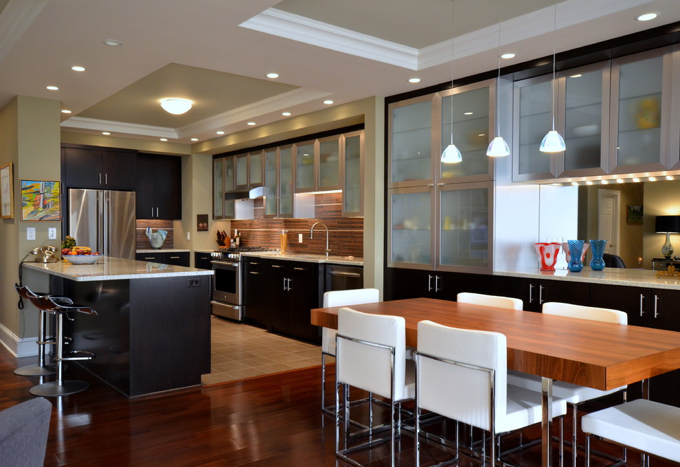 Design ideas for a contemporary u-shaped eat-in kitchen in Philadelphia with glass-front cabinets, stainless steel cabinets, brown splashback and stainless steel appliances.