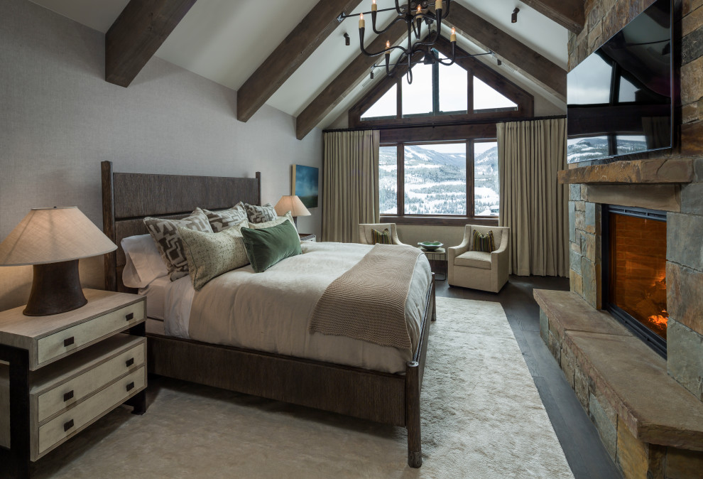 Aménagement d'une chambre parentale classique avec un plafond voûté, une cheminée standard et un manteau de cheminée en pierre.