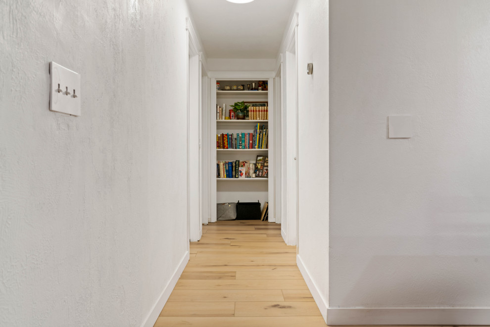 Esempio di un piccolo ingresso o corridoio boho chic con pareti bianche, pavimento in vinile e pavimento beige