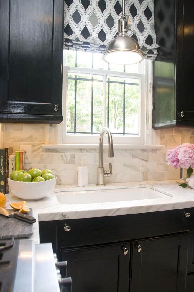 Mid-sized transitional kitchen in DC Metro with a single-bowl sink, black cabinets, marble benchtops, recessed-panel cabinets, white splashback, stone tile splashback and stainless steel appliances.
