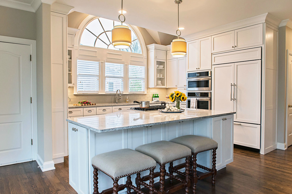 Inspiration for a mid-sized transitional l-shaped dark wood floor and brown floor eat-in kitchen remodel in Nashville with an undermount sink, recessed-panel cabinets, white cabinets, granite countertops, white backsplash, glass tile backsplash, stainless steel appliances, an island and gray countertops