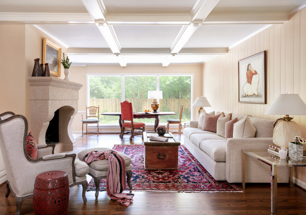Immagine di un soggiorno classico con pareti beige, pavimento in legno massello medio, camino classico, pavimento marrone e soffitto a cassettoni