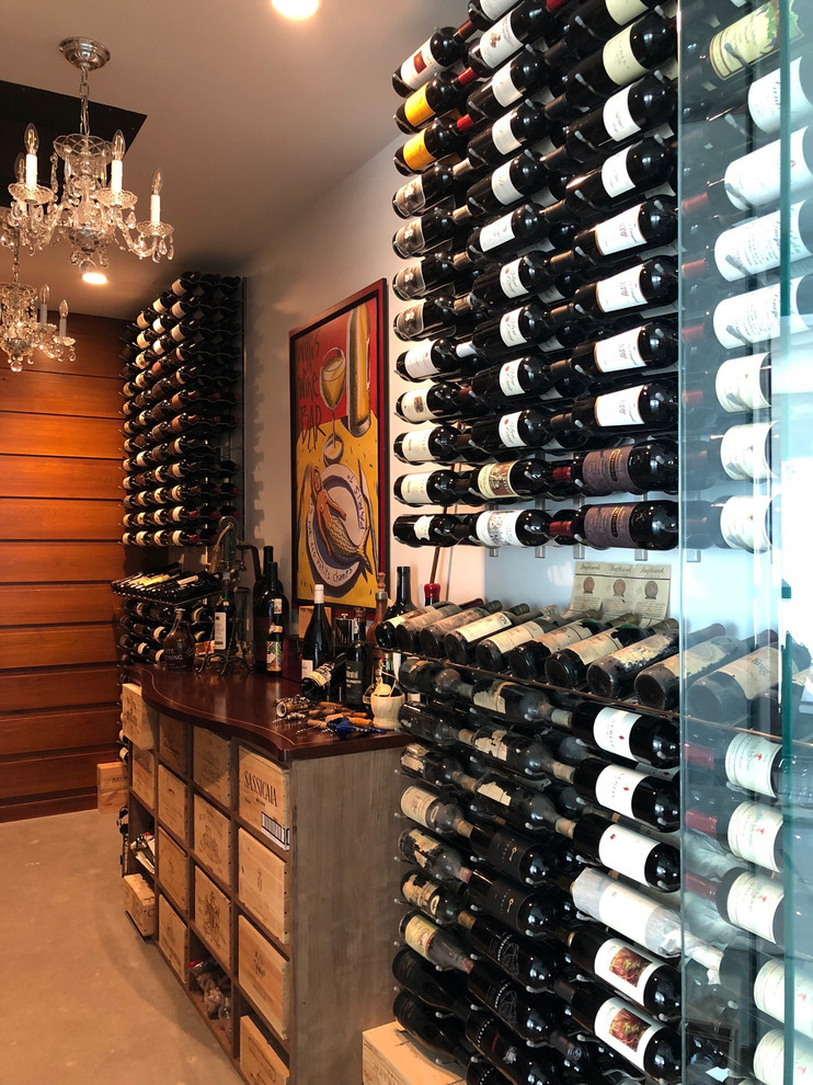 Inspiration for a mid-sized modern wine cellar in New York with concrete floors, display racks and grey floor.