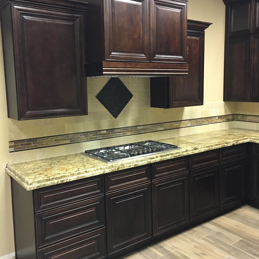 Inspiration for a mid-sized transitional l-shaped porcelain tile enclosed kitchen remodel in Austin with raised-panel cabinets, dark wood cabinets, granite countertops, beige backsplash, stone tile backsplash, stainless steel appliances and no island