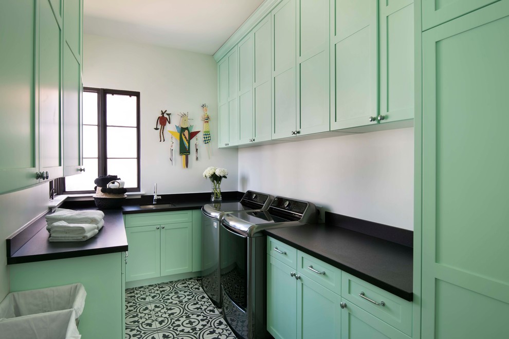 Inspiration for a mediterranean u-shaped dedicated laundry room in Phoenix with an undermount sink, shaker cabinets, green cabinets, white walls, a side-by-side washer and dryer and multi-coloured floor.