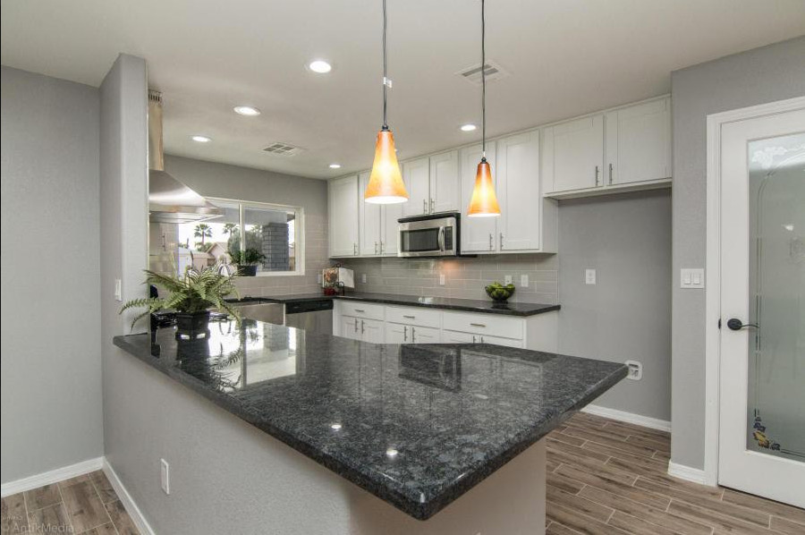 Open concept kitchen - mid-sized u-shaped open concept kitchen idea in Phoenix with recessed-panel cabinets, white cabinets, gray backsplash, subway tile backsplash, stainless steel appliances and no island
