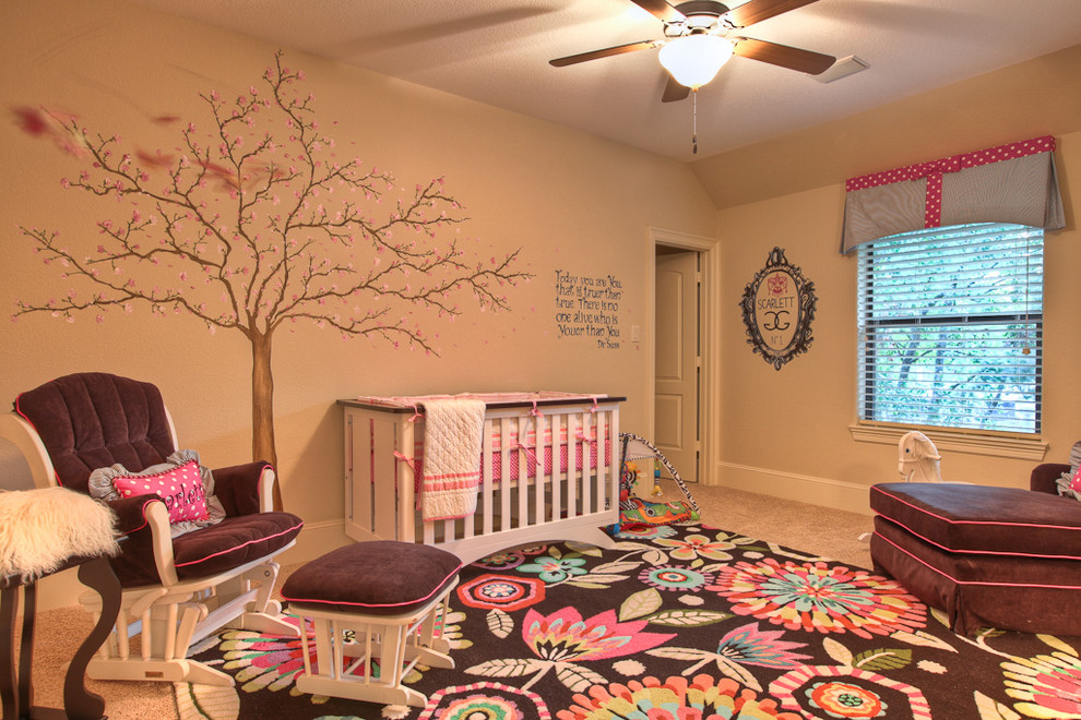 This is an example of a traditional nursery for girls in Houston with beige walls and carpet.