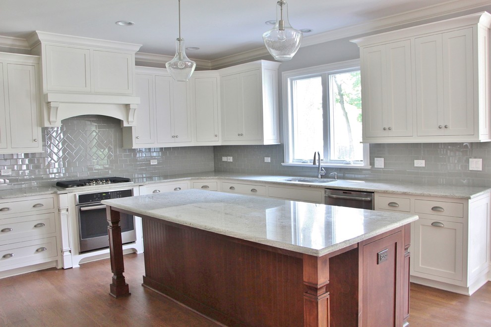This is an example of a large transitional u-shaped eat-in kitchen in Chicago with a double-bowl sink, shaker cabinets, white cabinets, granite benchtops, grey splashback, glass tile splashback, stainless steel appliances, medium hardwood floors and with island.