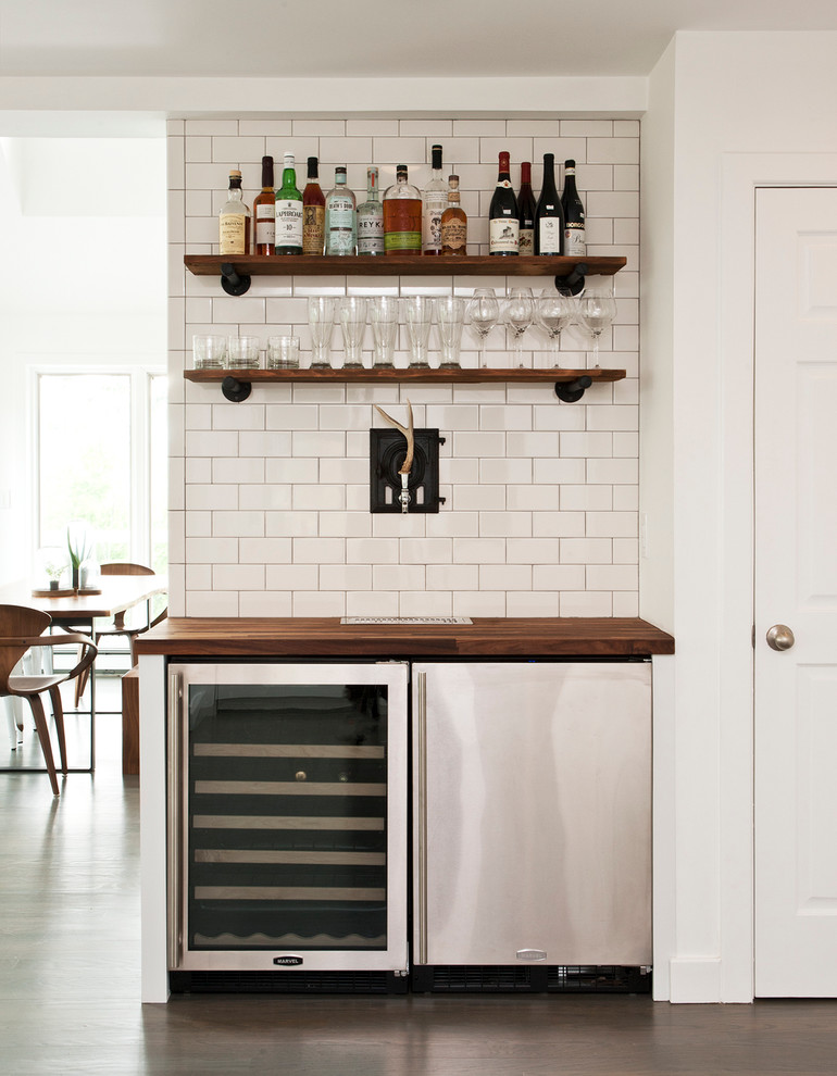 Design ideas for a small contemporary single-wall home bar in New York with wood benchtops, white splashback, subway tile splashback and brown benchtop.