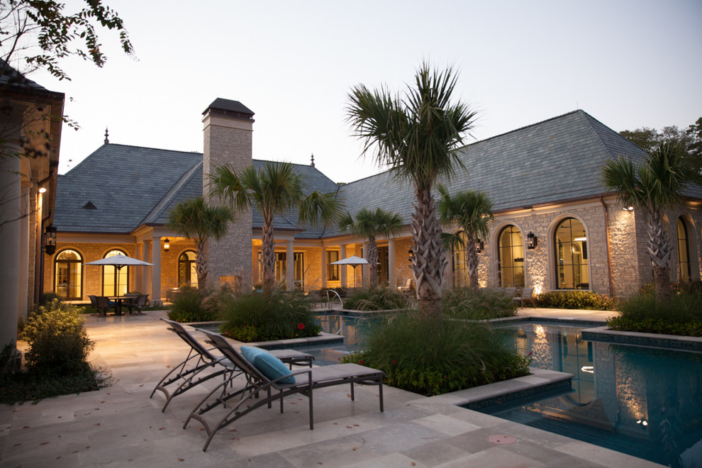 This is an example of a mediterranean backyard custom-shaped infinity pool in Houston with tile.