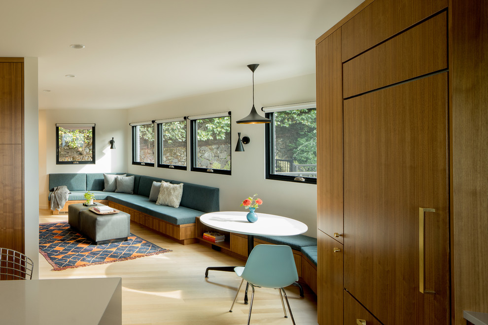 This is an example of a mid-sized midcentury eat-in kitchen in Portland with flat-panel cabinets, medium wood cabinets, light hardwood floors and with island.