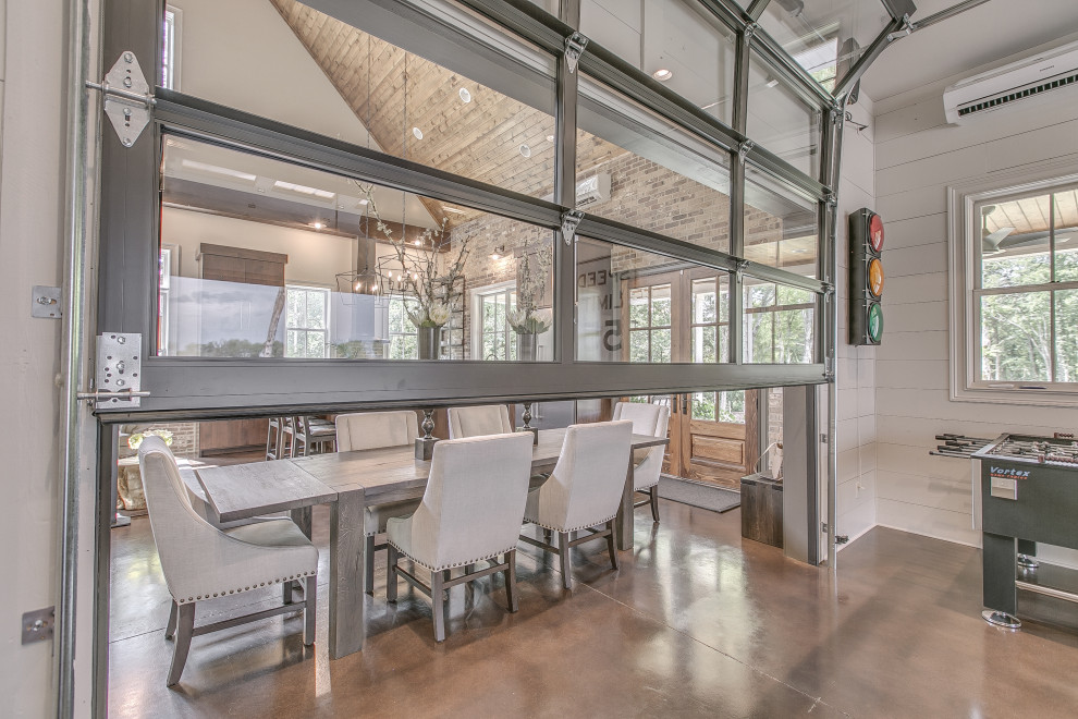 Immagine di una sala da pranzo aperta verso la cucina country con pareti bianche, pavimento in cemento, pavimento grigio, soffitto a volta, soffitto in legno e pareti in mattoni