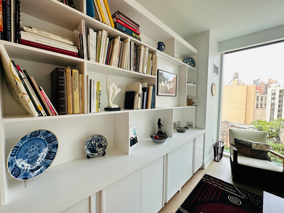 Источник вдохновения для домашнего уюта: открытая гостиная комната среднего размера в стиле модернизм с с книжными шкафами и полками, белыми стенами, паркетным полом среднего тона и коричневым полом без телевизора