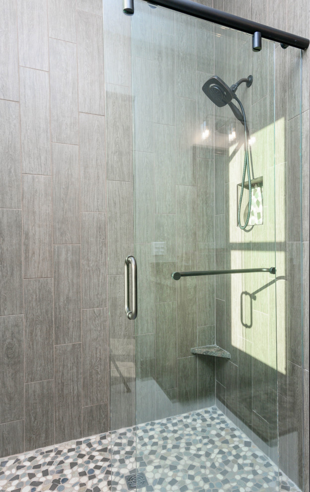 Transitional 3/4 brown tile and ceramic tile mosaic tile floor and multicolored floor walk-in shower photo with shaker cabinets, dark wood cabinets, gray walls, an undermount sink and multicolored countertops