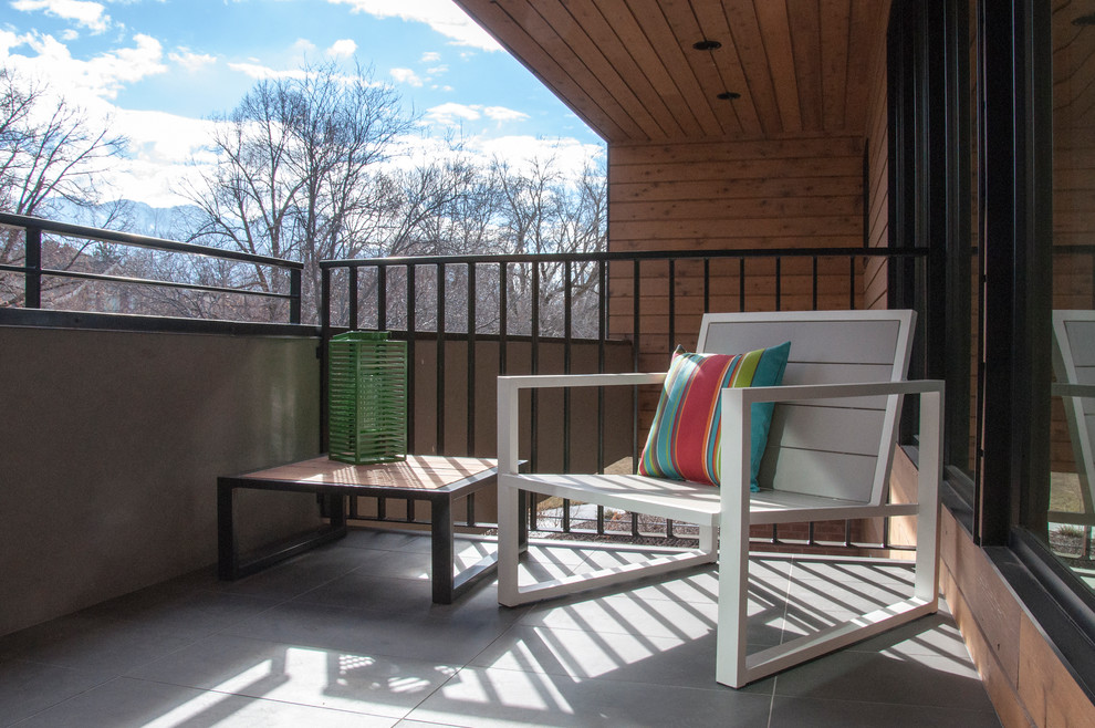 This is an example of a mid-sized contemporary balcony in Salt Lake City with a roof extension.