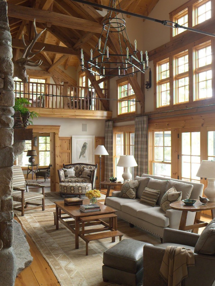 Photo of a country open concept living room in Boston with white walls, medium hardwood floors, a standard fireplace, a stone fireplace surround and brown floor.