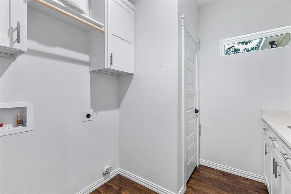 Design ideas for a mid-sized transitional single-wall utility room in Houston with a drop-in sink, shaker cabinets, white cabinets, quartzite benchtops, white splashback, white walls, light hardwood floors, a side-by-side washer and dryer, brown floor, white benchtop, coffered and panelled walls.