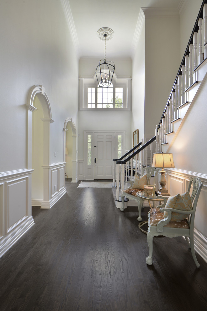 This is an example of a traditional foyer in Austin with white walls, dark hardwood floors, a single front door and a white front door.