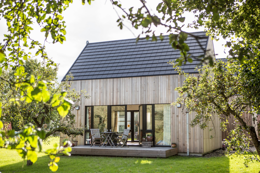 Kleine, Unbedeckte Nordische Terrasse hinter dem Haus mit Kübelpflanzen in Hamburg