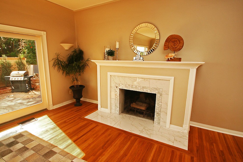 This is an example of a transitional living room in Orange County with beige walls, medium hardwood floors, a standard fireplace and a tile fireplace surround.