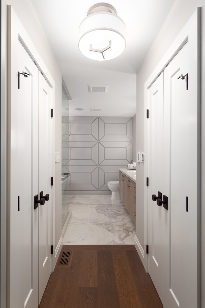 Inspiration for a mid-sized contemporary master bathroom in Vancouver with flat-panel cabinets, medium wood cabinets, a freestanding tub, a corner shower, marble, grey walls, marble floors, an undermount sink, solid surface benchtops, white floor and a sliding shower screen.