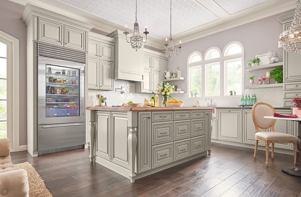 Design ideas for a large traditional l-shaped separate kitchen in Other with a farmhouse sink, raised-panel cabinets, grey cabinets, granite benchtops, white splashback, subway tile splashback, stainless steel appliances, dark hardwood floors, with island and brown floor.