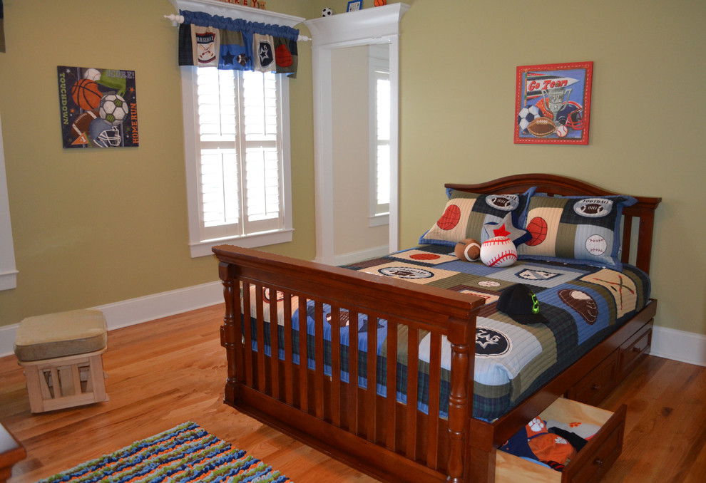 This is an example of a traditional kids' bedroom for boys in Charleston with green walls and light hardwood floors.