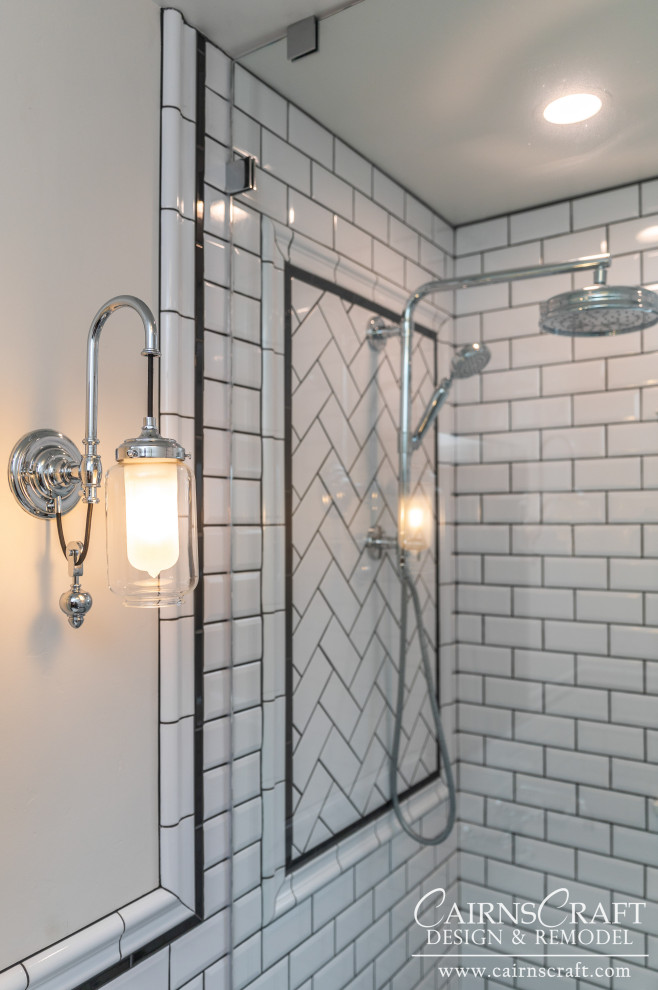 Klassisk inredning av ett litet badrum med dusch, med en öppen dusch, en toalettstol med separat cisternkåpa, svart och vit kakel, tunnelbanekakel, vita väggar, mosaikgolv, ett väggmonterat handfat, vitt golv och med dusch som är öppen