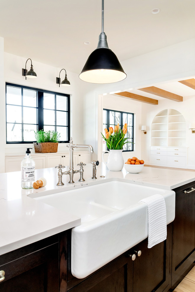 Inspiration for a large timeless u-shaped light wood floor open concept kitchen remodel in Other with a farmhouse sink, recessed-panel cabinets, white cabinets, quartzite countertops, gray backsplash, ceramic backsplash, stainless steel appliances, an island and white countertops