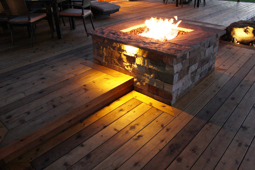 Photo of a large contemporary backyard deck in Kansas City with a fire feature and no cover.