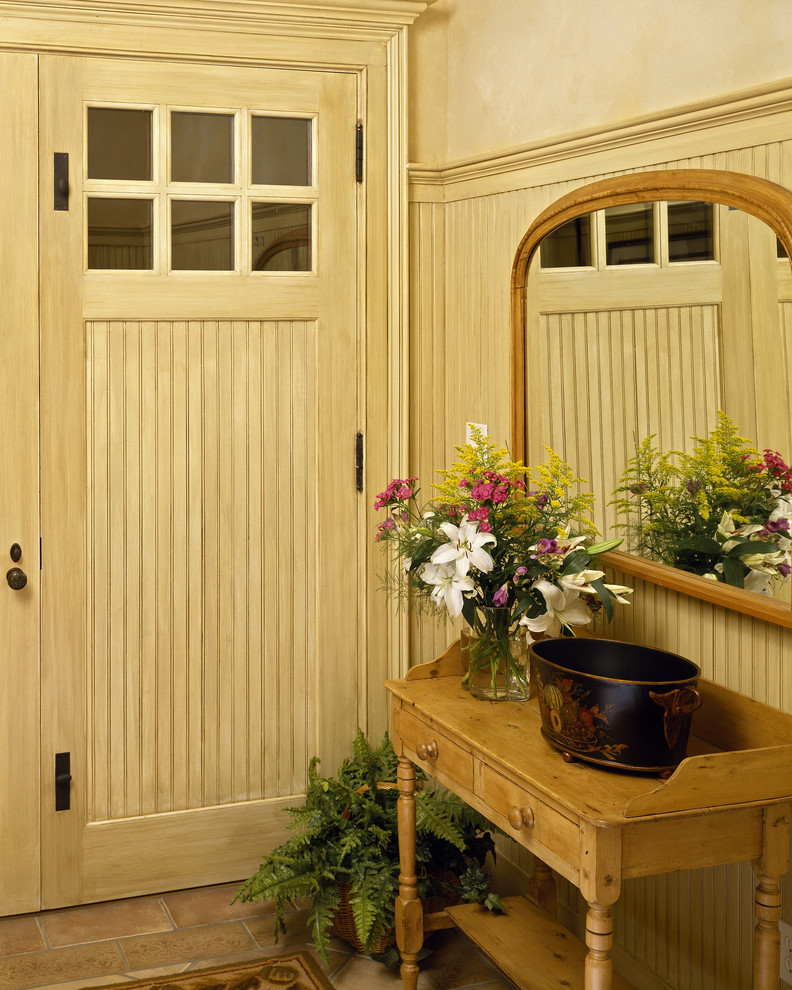 Traditional entryway in New York with a single front door and a light wood front door.