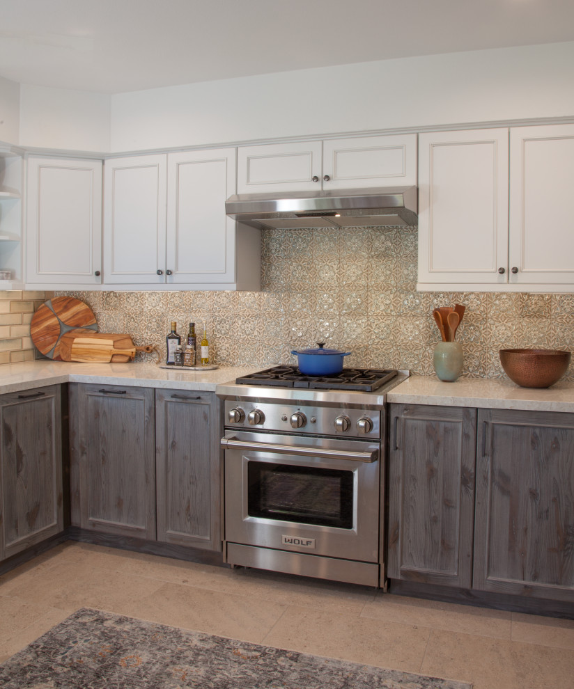 Photo of a mid-sized transitional u-shaped eat-in kitchen in San Diego with a triple-bowl sink, shaker cabinets, distressed cabinets, quartz benchtops, blue splashback, ceramic splashback, stainless steel appliances, porcelain floors, a peninsula, white floor and white benchtop.