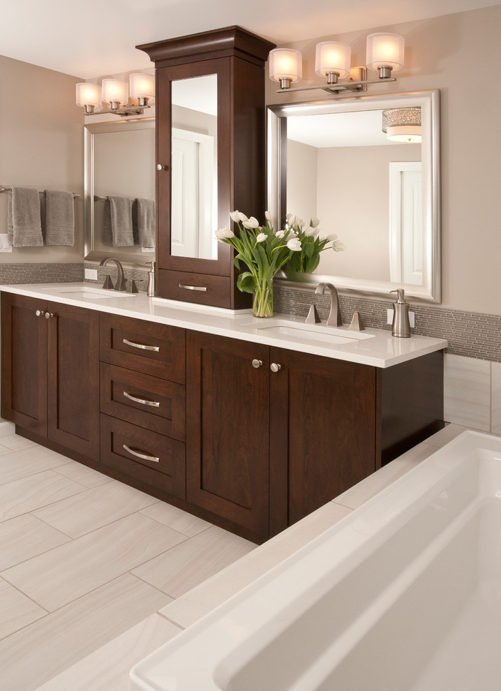Large transitional master bathroom in Seattle with an undermount sink, shaker cabinets, dark wood cabinets, engineered quartz benchtops, a drop-in tub, an alcove shower, a one-piece toilet, beige tile, porcelain tile, brown walls and porcelain floors.
