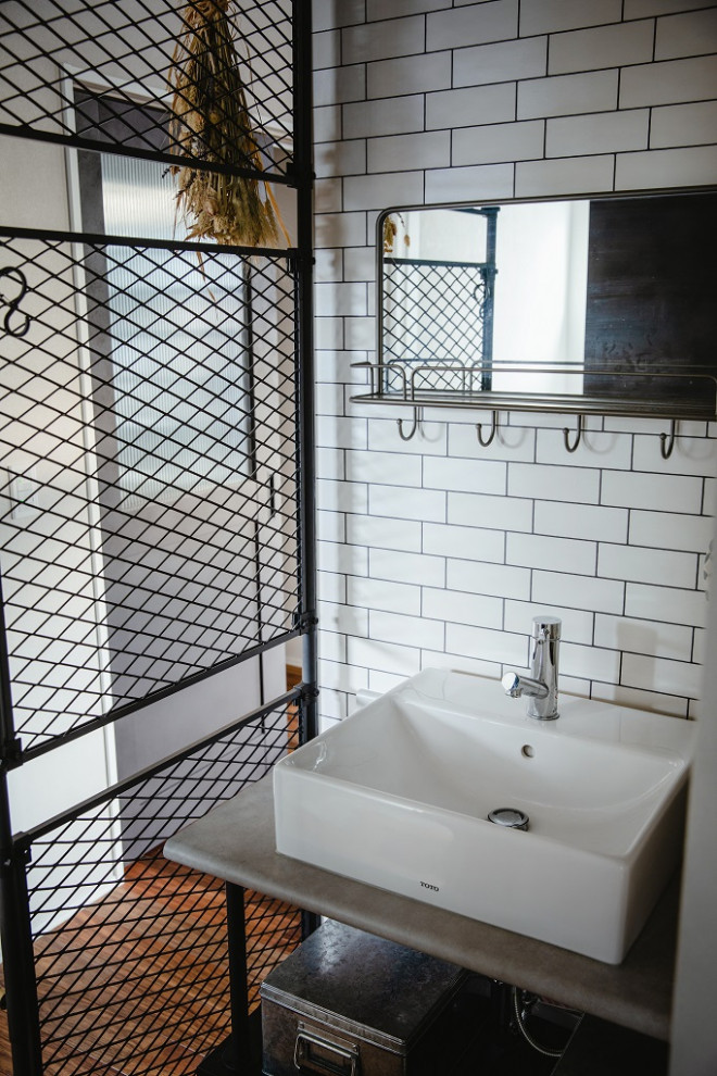 他の地域にあるインダストリアルスタイルのおしゃれなトイレ・洗面所 (グレーのキャビネット、白いタイル、造り付け洗面台、クロスの天井、壁紙) の写真