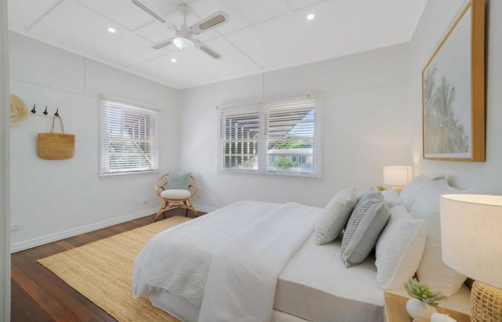 Example of a mid-sized beach style master medium tone wood floor and brown floor bedroom design in Brisbane with white walls