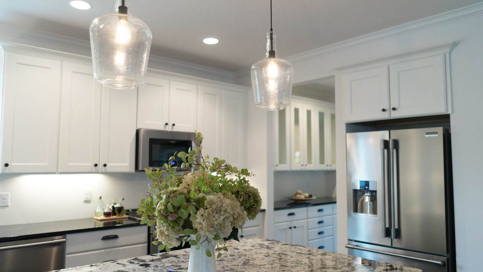 Mid-sized transitional l-shaped dark wood floor open concept kitchen photo with an undermount sink, shaker cabinets, white cabinets, granite countertops, gray backsplash, stainless steel appliances and an island