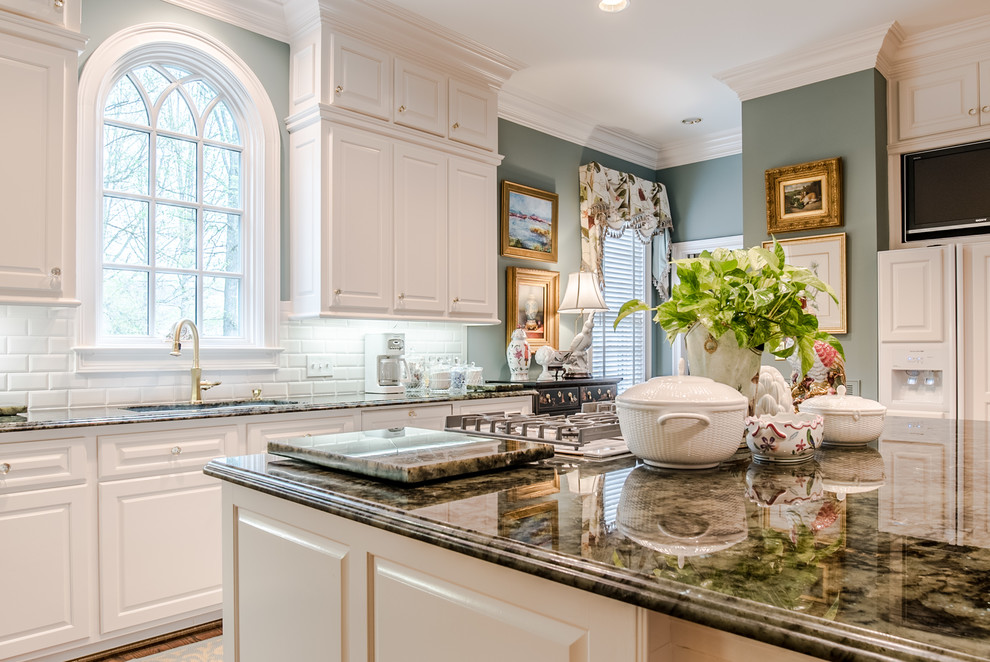 Inspiration for a large contemporary galley eat-in kitchen in Raleigh with an undermount sink, shaker cabinets, white cabinets, quartzite benchtops, subway tile splashback, white appliances, medium hardwood floors, with island and brown floor.