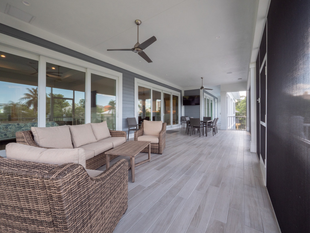 This is an example of a beach style screened-in verandah in Miami.