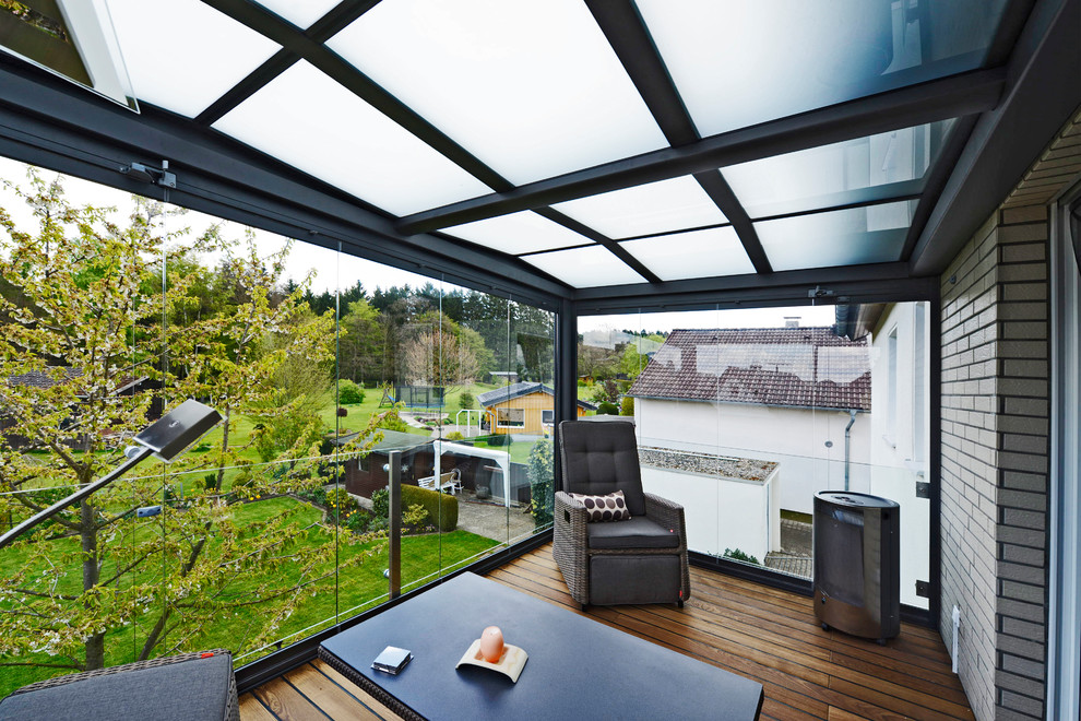 Mittelgroßer Moderner Wintergarten mit dunklem Holzboden, Glasdecke und braunem Boden in Dortmund