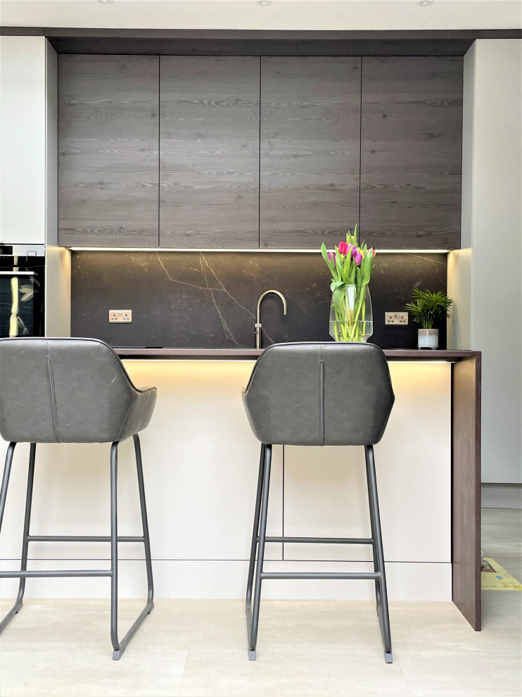 Photo of a large contemporary single-wall open plan kitchen in Other with a single-bowl sink, flat-panel cabinets, medium wood cabinets, quartz benchtops, grey splashback, black appliances, vinyl floors, with island, grey floor and grey benchtop.