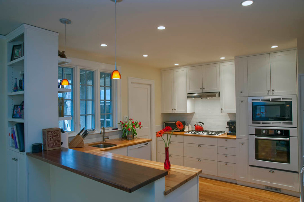 This is an example of a traditional u-shaped kitchen in Boston with an undermount sink, shaker cabinets and white cabinets.