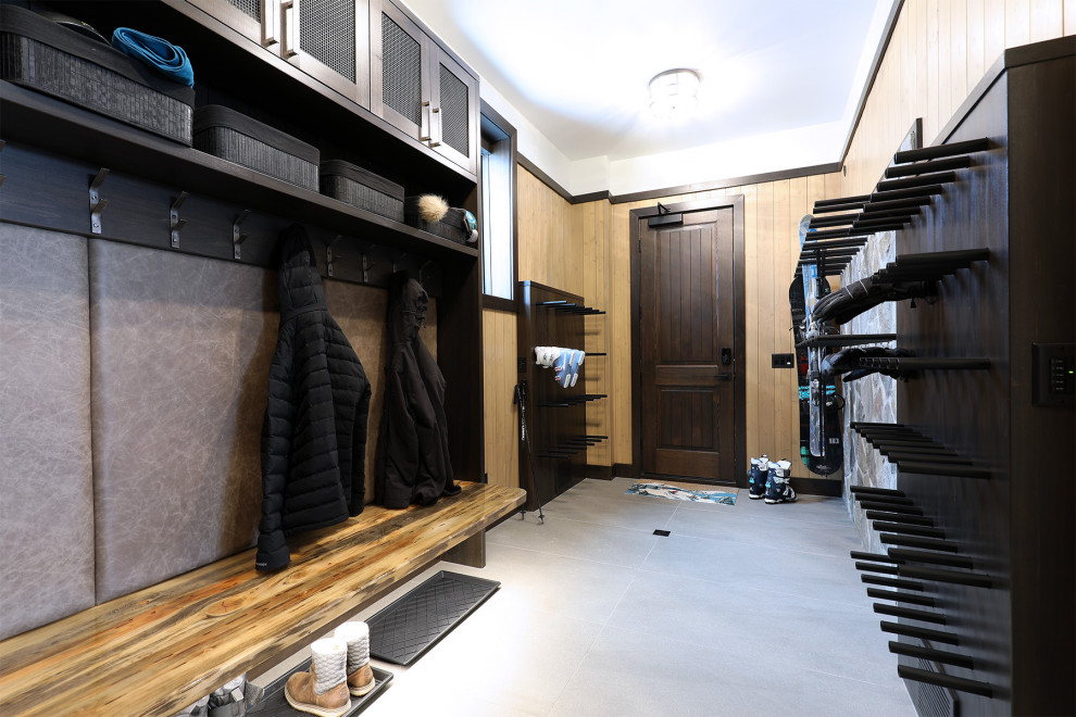 Mudroom - large rustic porcelain tile, gray floor and wainscoting mudroom idea in Vancouver with brown walls and a dark wood front door