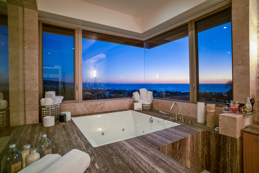 Design ideas for a large contemporary master bathroom in San Diego with flat-panel cabinets, brown cabinets, a hot tub, a curbless shower, a one-piece toilet, beige tile, stone tile, white walls, travertine floors, a drop-in sink, marble benchtops, white floor, an open shower and multi-coloured benchtops.