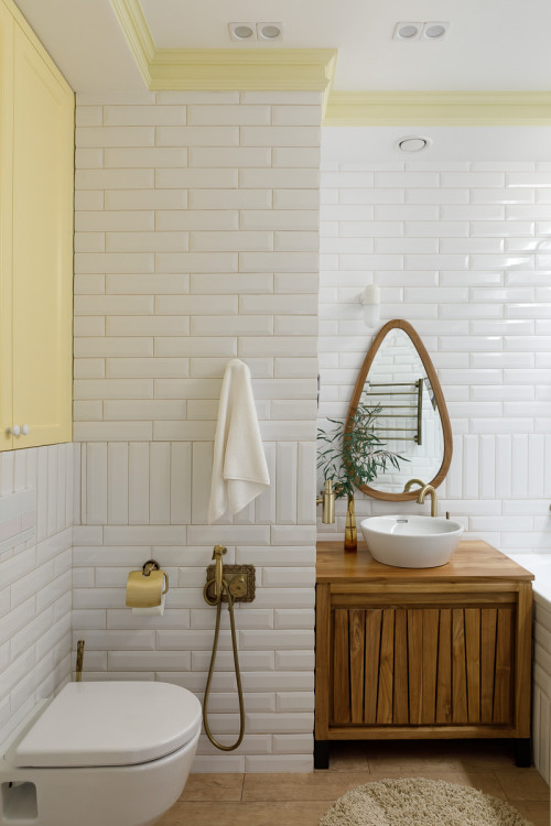 White Subway Tile Backsplash with Wood Vanity and Yellow Cabinets