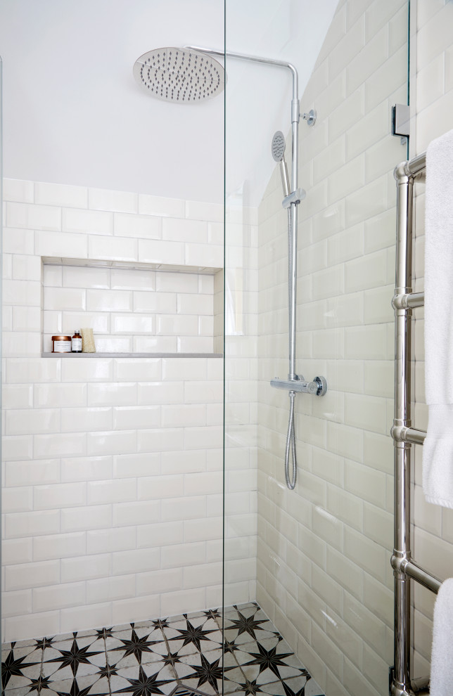 This is an example of a mid-sized arts and crafts 3/4 wet room bathroom in London with flat-panel cabinets, grey cabinets, a two-piece toilet, beige tile, ceramic tile, terra-cotta floors, a wall-mount sink, marble benchtops, multi-coloured floor, a hinged shower door, multi-coloured benchtops, a single vanity, a freestanding vanity and brick walls.