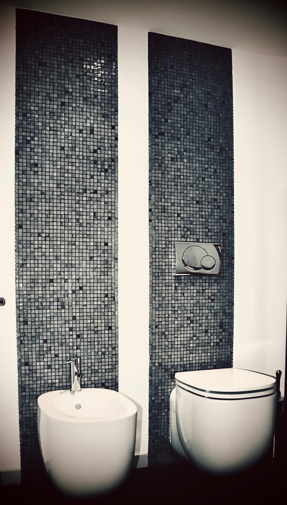 This is an example of a mid-sized modern master bathroom with an alcove tub, an alcove shower, a two-piece toilet, gray tile, white walls, dark hardwood floors, a double vanity and recessed.