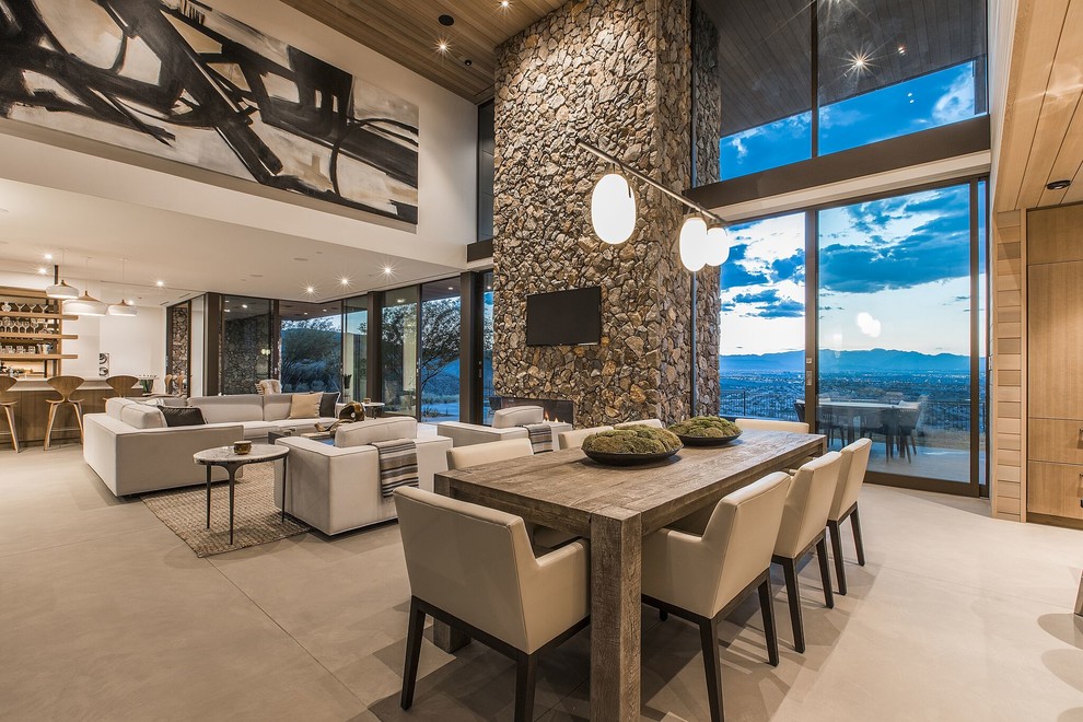 Design ideas for a large contemporary open plan dining in Las Vegas with beige floor, white walls, concrete floors, a standard fireplace and a stone fireplace surround.