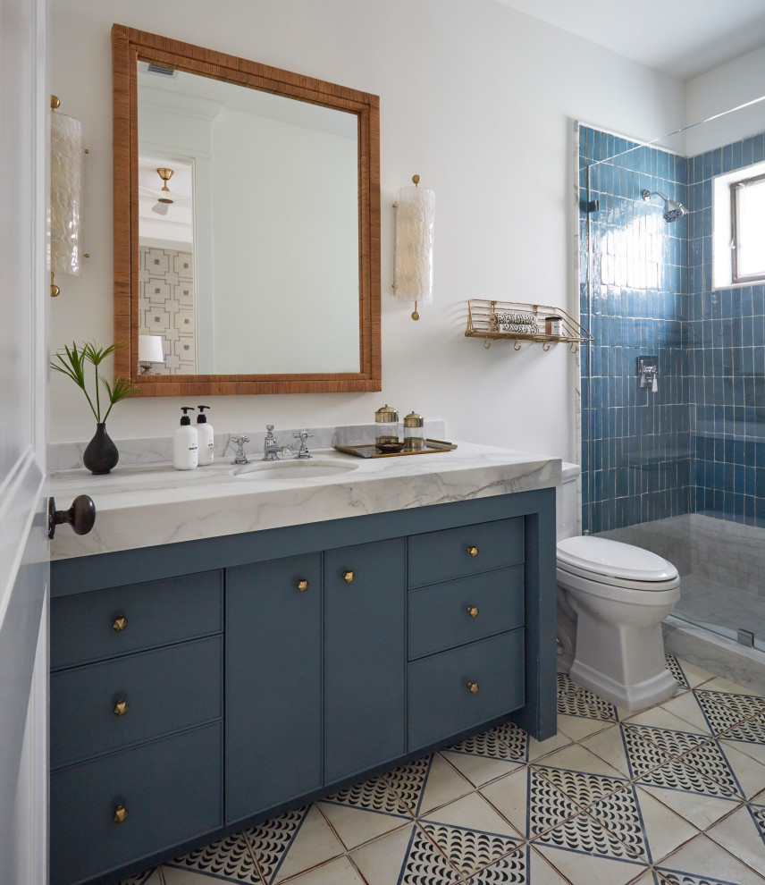 Ispirazione per una stanza da bagno costiera con ante lisce, ante blu, doccia alcova, piastrelle blu, pareti bianche, lavabo sottopiano, top bianco e un lavabo