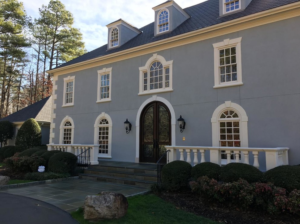 Design ideas for an expansive traditional three-storey stucco blue exterior in Raleigh with a gable roof.